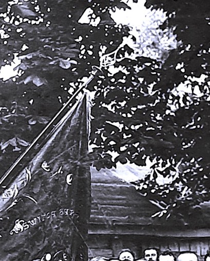 Powiększony element sztandaru na fotografii. Napis „Święta Barbaro módl się za nami” oraz wyhaftowana postać Świętej Barbary. Widoczny grot z symbolami cechu rzeźników.