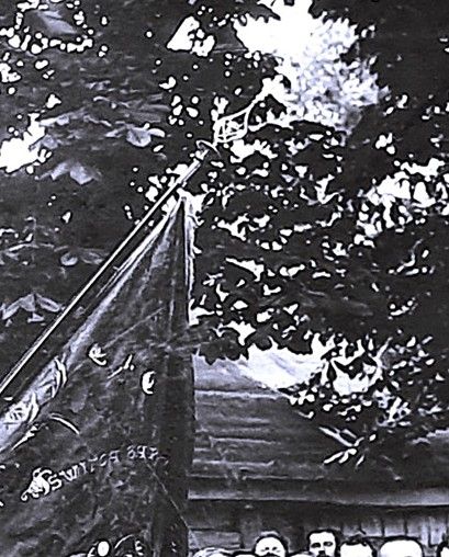 Powiększony element sztandaru na fotografii. Napis „Święta Barbaro módl się za nami” oraz wyhaftowana postać Świętej Barbary. Widoczny grot z symbolami cechu rzeźników.